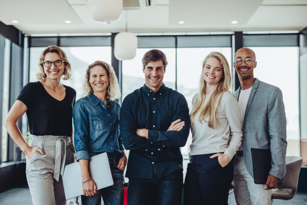 Team_von_Mitarbeitenden_im_Buero glückliche, entspannte, resiliente Mitarbeitende im Büro