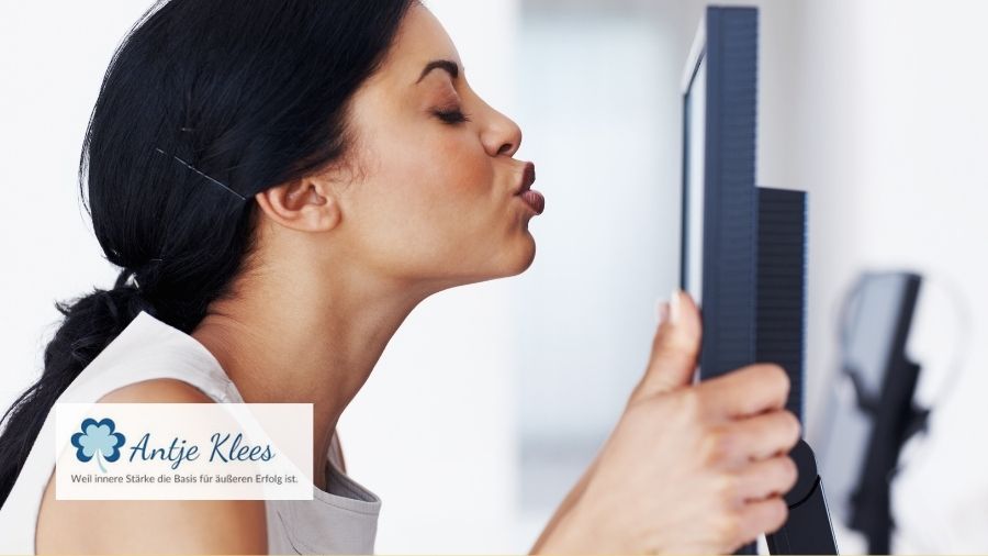 Eine Frau küsst auf Arbeit ihren Bildschirm.