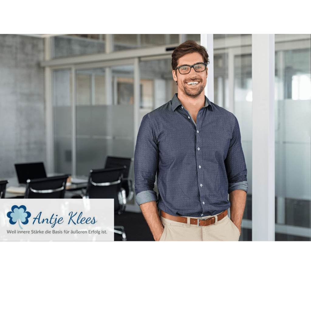 Mitarbeitender steht im Büro und lächelt